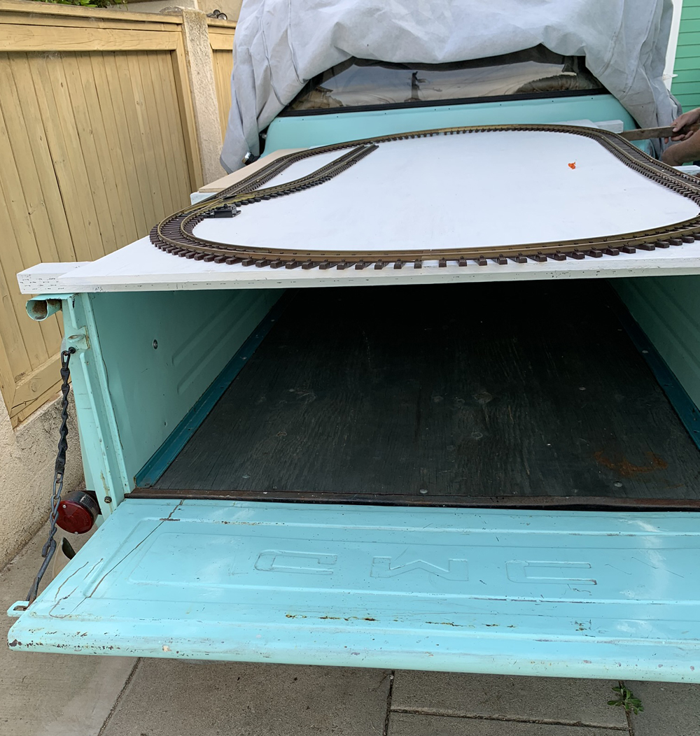 Back of a pickup truck with plywood and track on top