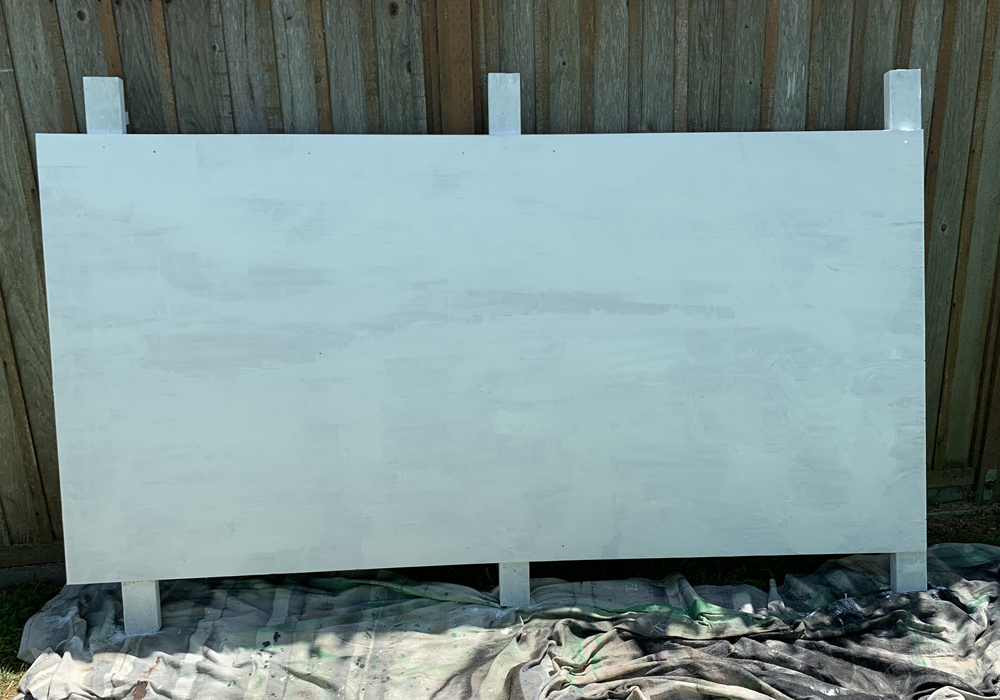 Plywood leaning against a fence