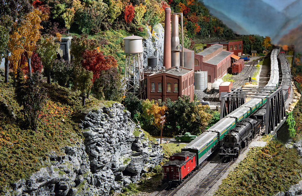 A reefer train and a coal drag pass each other near a paper mill in the West Virginia mountains