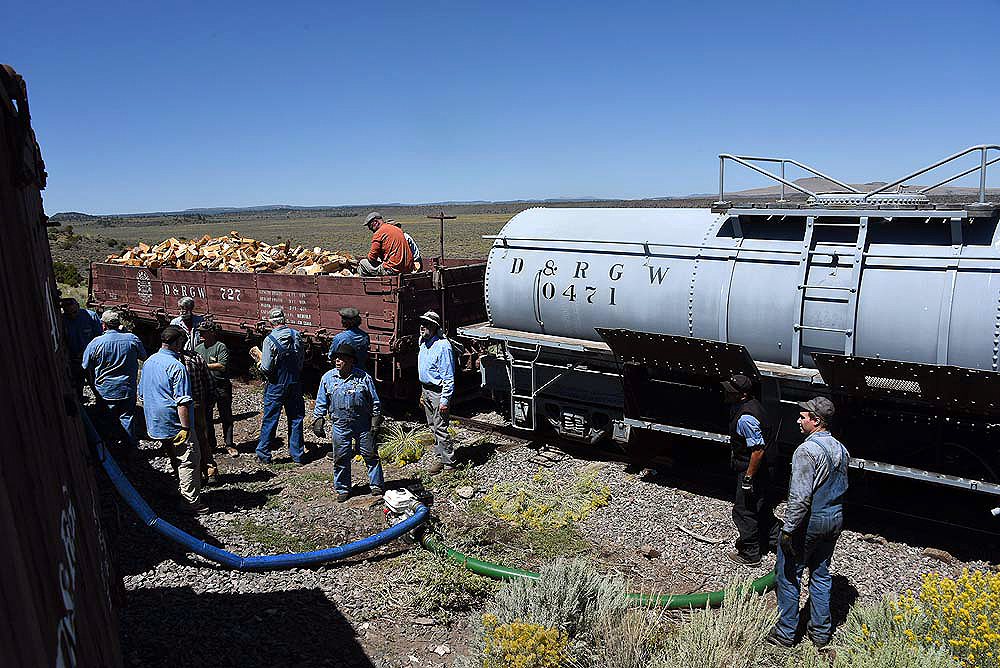 Crews loading wood and water into a train.