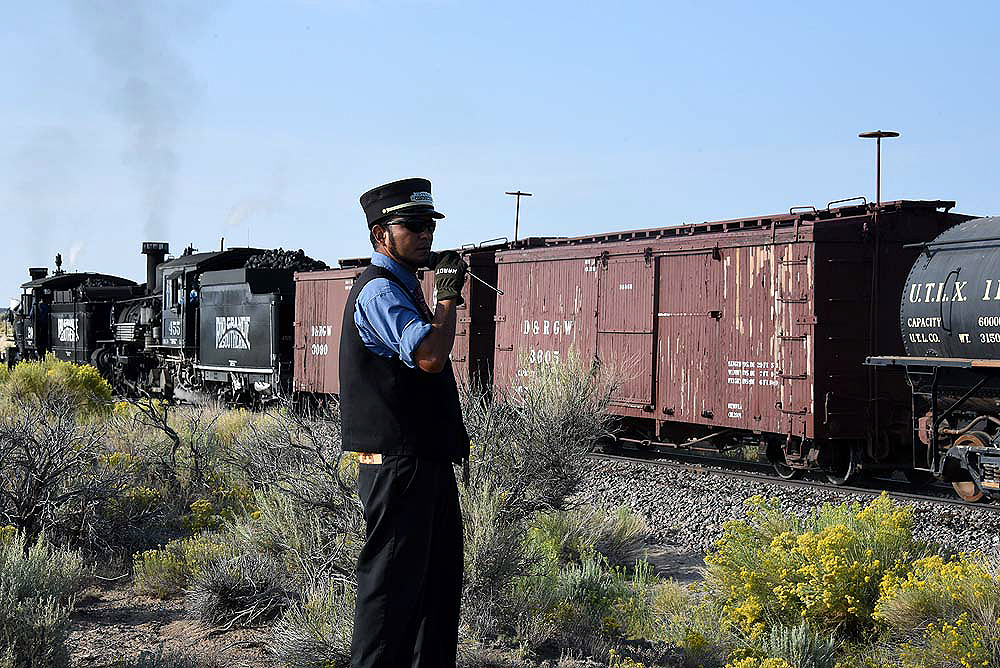 Conductor sending a hand signal to a train.