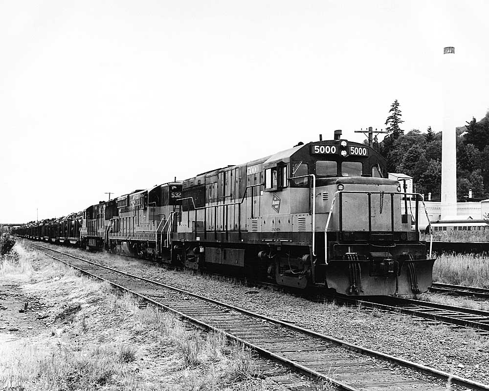 Three diesel locomotives on train of logs