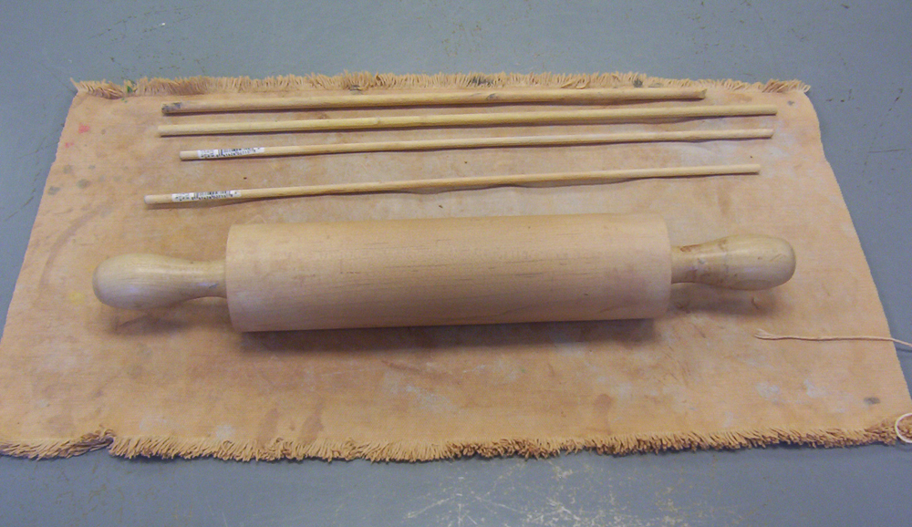 A rolling pin and dowels resting on a piece of canvas