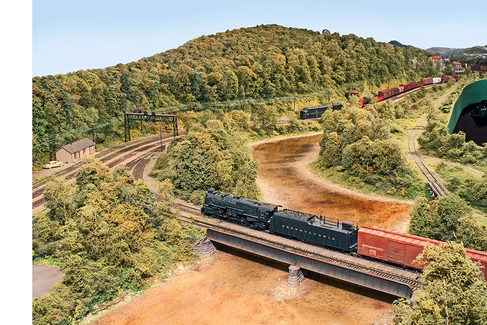 A steampowered freight passes over a winding creek