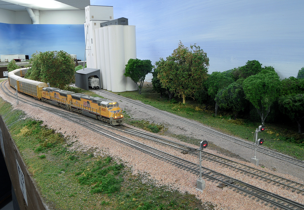 Yellow Union Pacific locomotives lead a freight train around a curve.