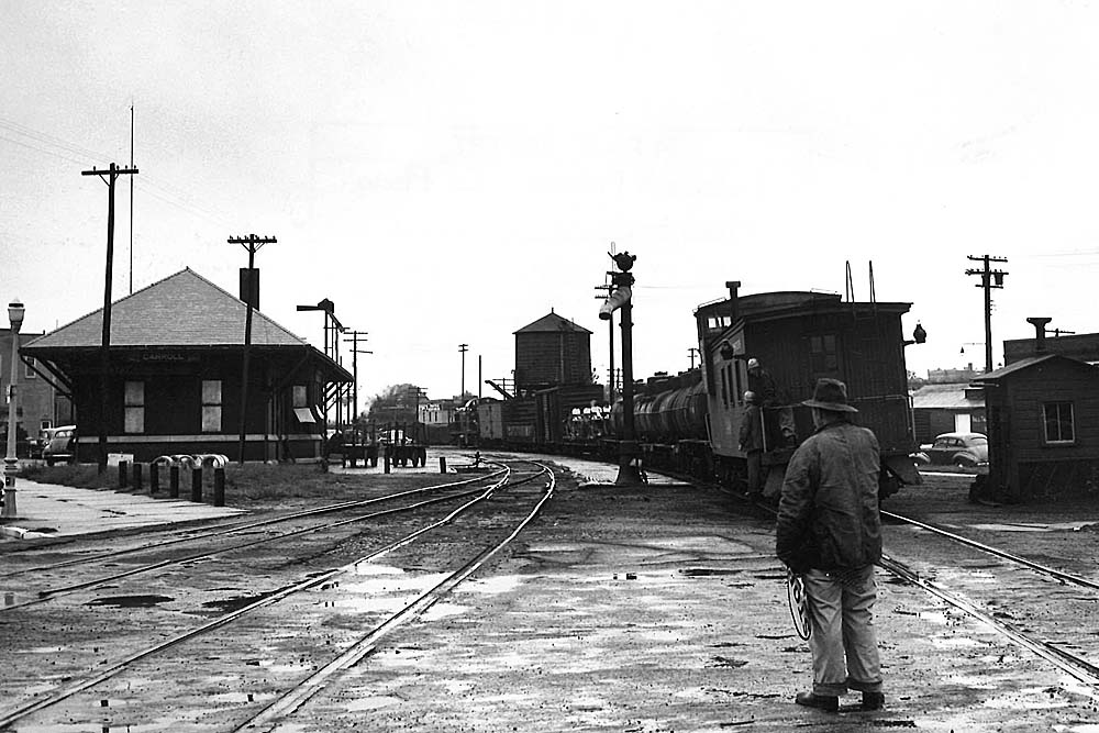 Man stands in street after short train passes.
