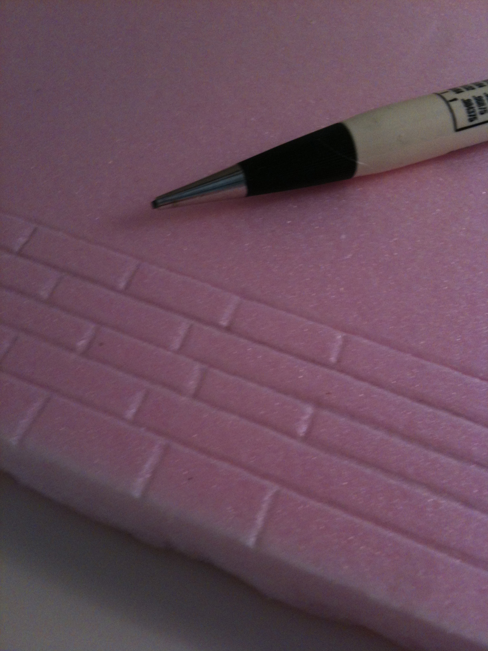 Mechanical pencil on top of pink insulation foam