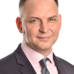 Man with coat, tie, and pink shirt