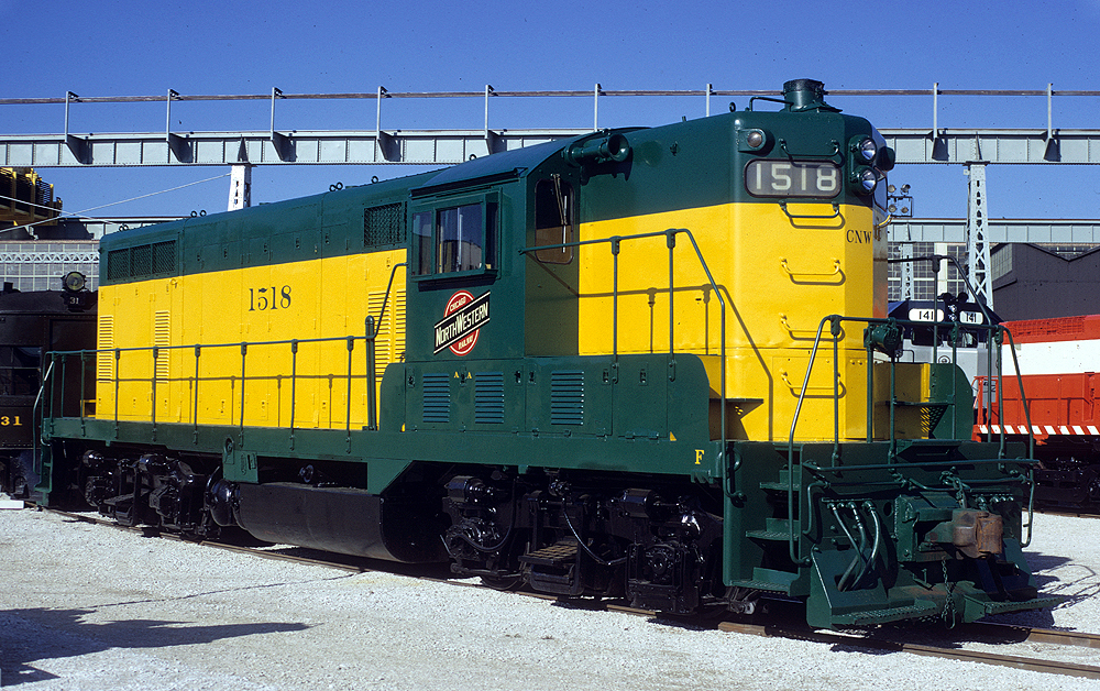 Top preserved diesel locomotives: A green and yellow painted diesel locomotive under a clear sky.