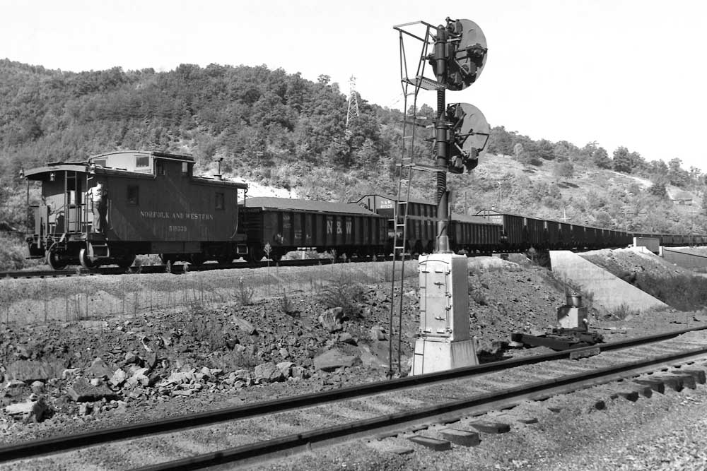 Train passes behind signal on elevated trackage