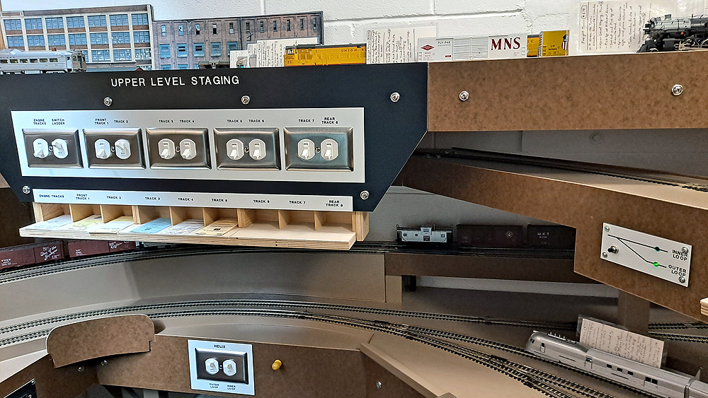 A panel of duplex wall switches is mounted to a neatly labeled Formica panel.