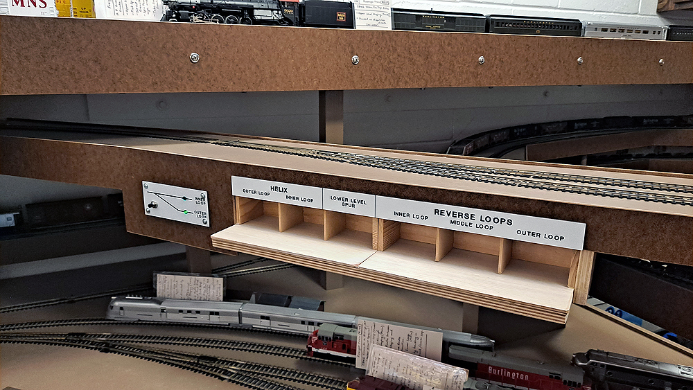 Car card boxes are mounted horizontally to the bottom of the benchwork.