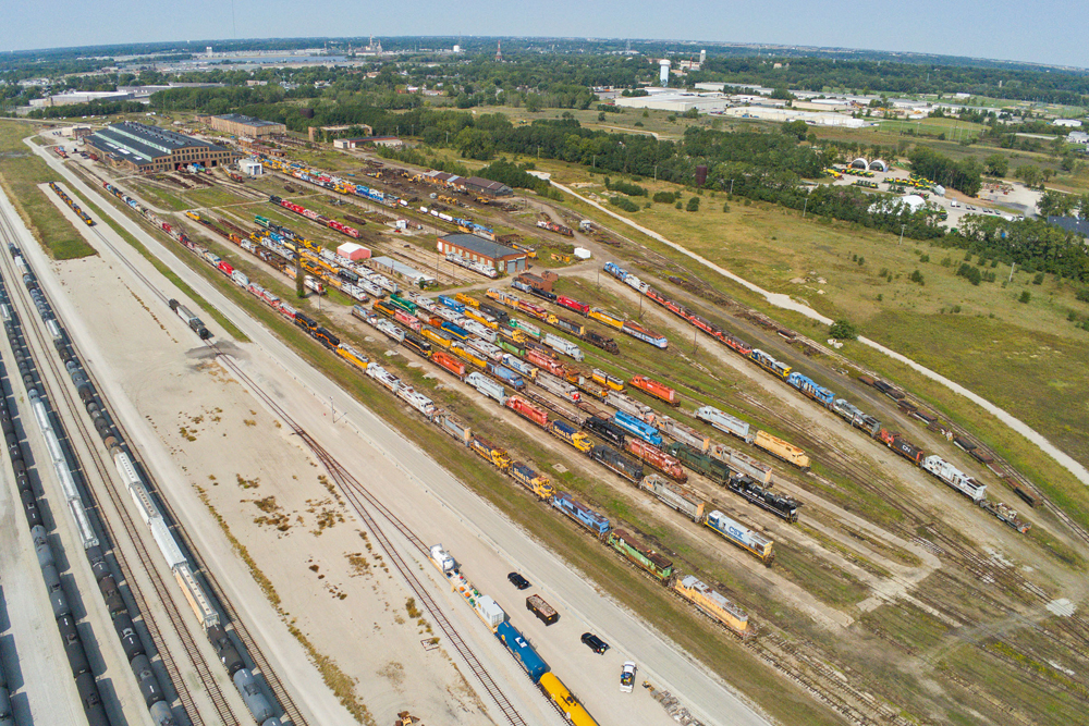 Aerial view of shop complex with dozens of locomotives in many paint schemes