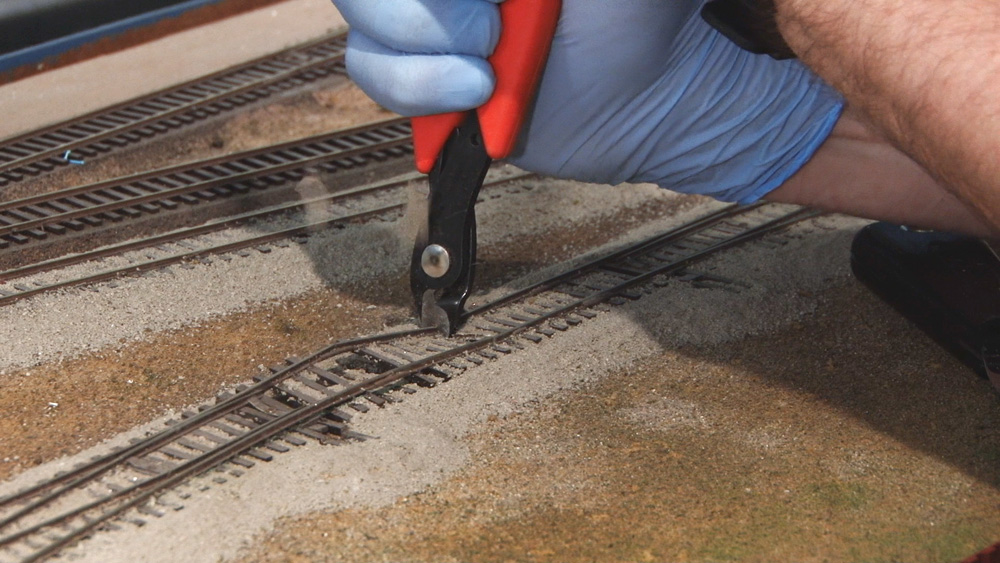 Pieces of flex track being cut off of layout.