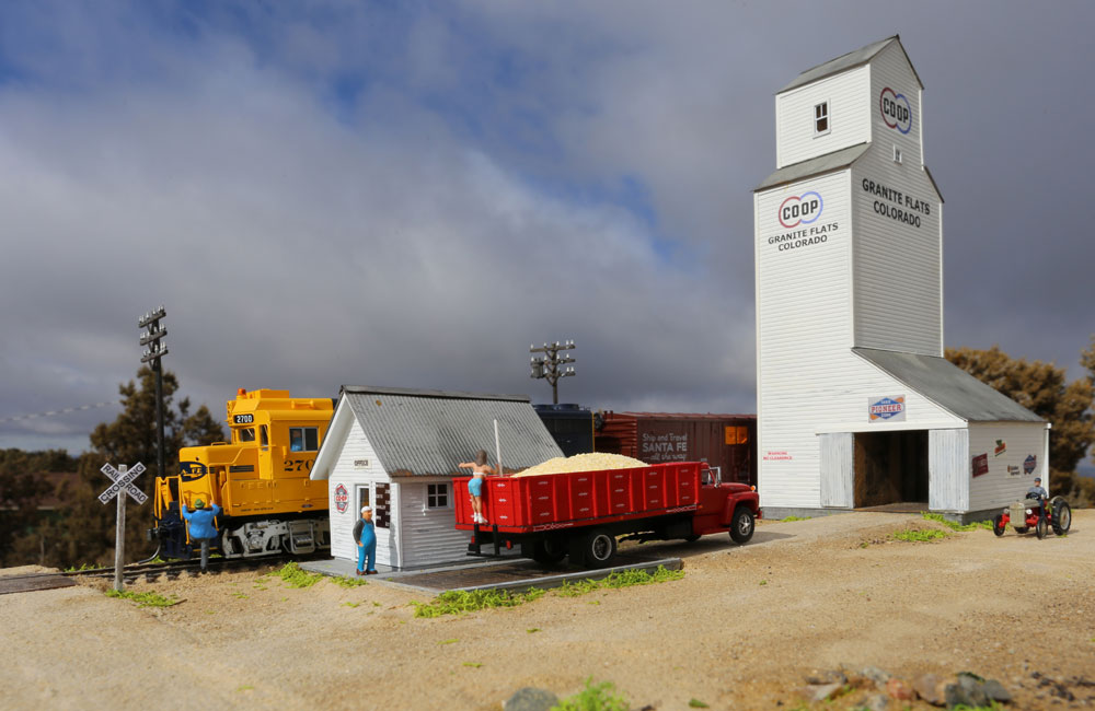 A young woman climbs the back of a grain truck on the scale at a grain elevator