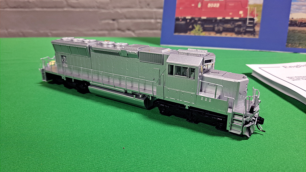 Silver painted preproduction sample locomotive on green tablecloth.