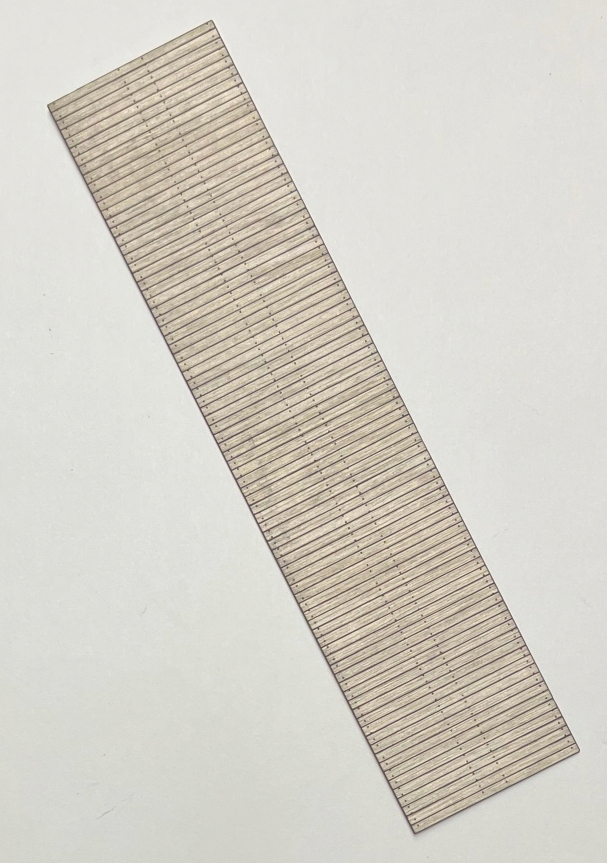 Photo of laser-cut wood flatcar deck on white background.