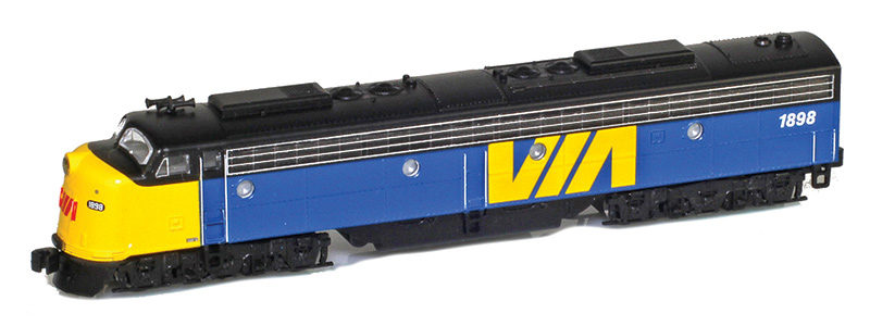 Z scale six-axle diesel locomotive painted yellow, blue, and black on white background.