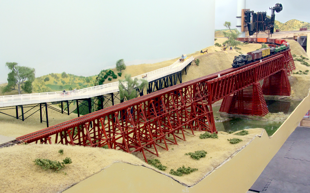 Don Ball model railroad images: Steam-era freight train crossing over bridge on scenicked model railroad.