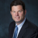 Dark-haired man in coat and tie