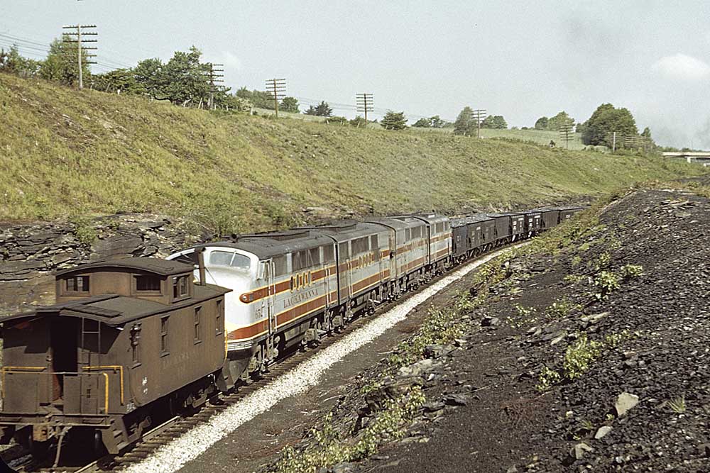 Four-unit streamlined diesel set on rear of freight train ahead of caboose