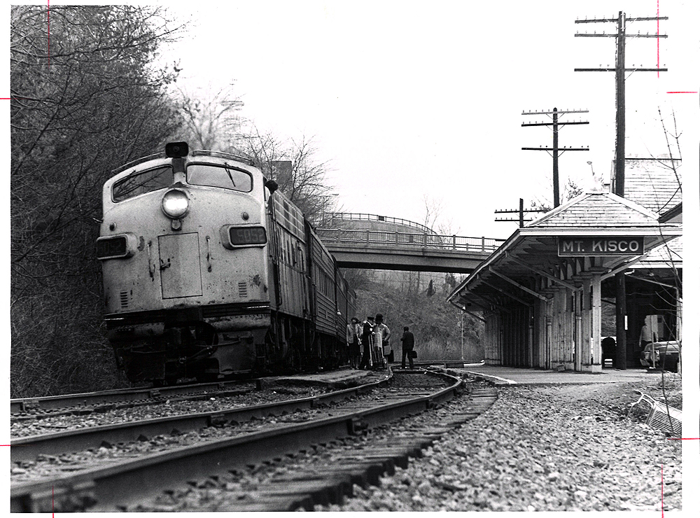 Conrail passenger trains: A beat up streamlined locomotive at the head of a passenger train at a station.