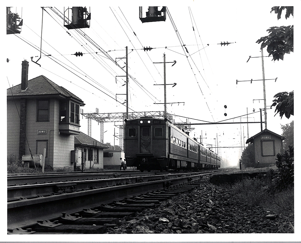 Conrail passenger trains: Electric multiple units under catenary stop at a station.
