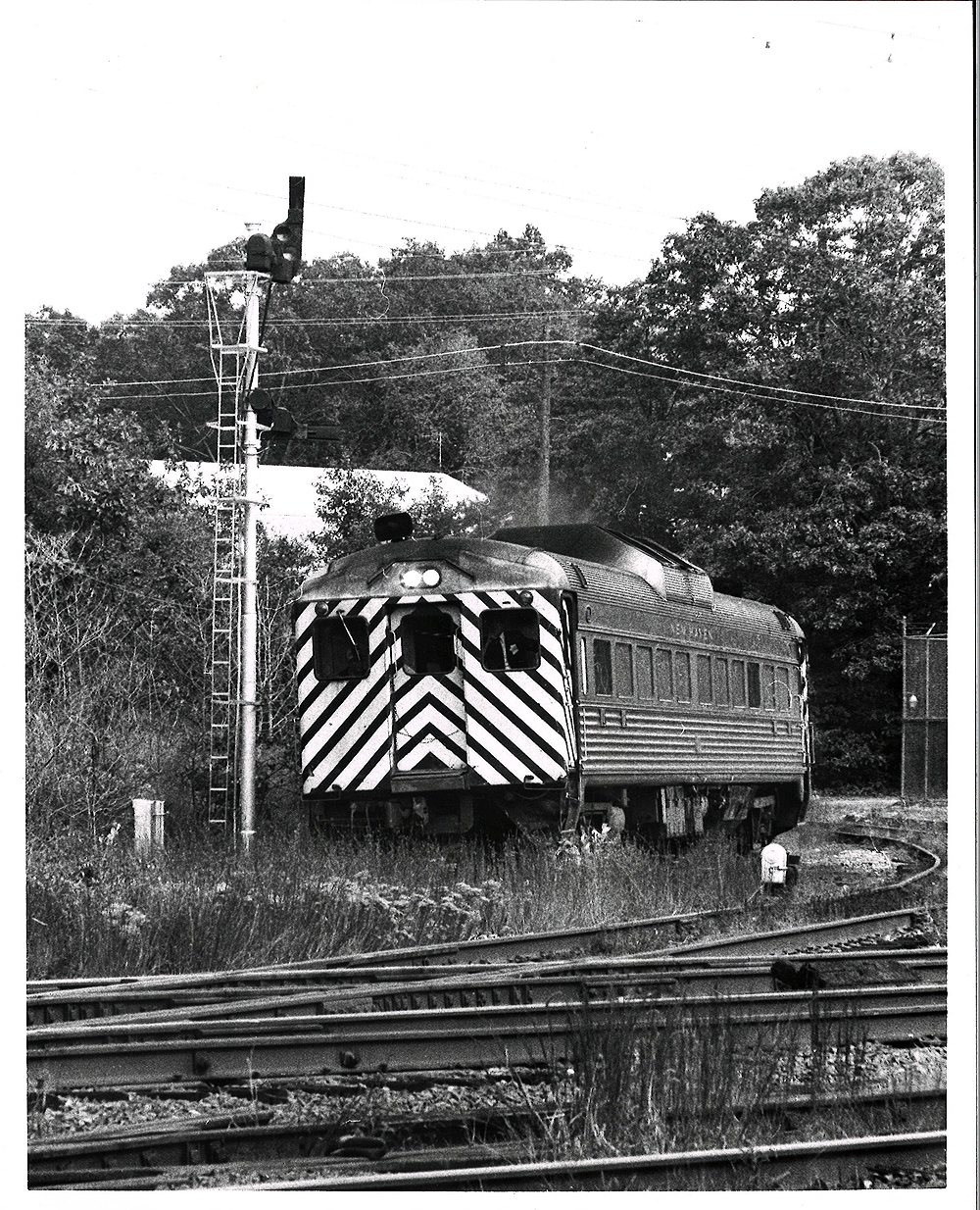 Conrail passenger trains: Stipped rail diesel car next to semaphore signal.