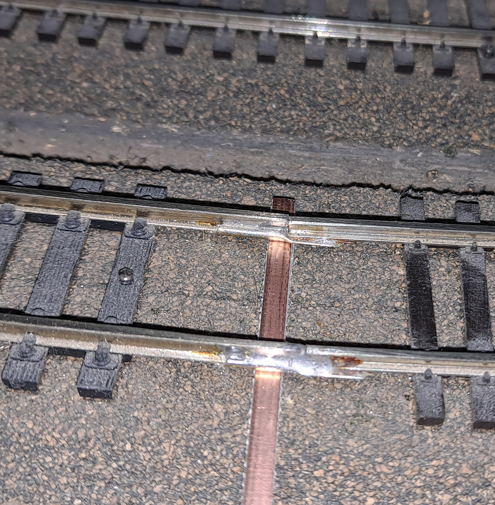 A piece of printed-circuit board tie is placed under the track.