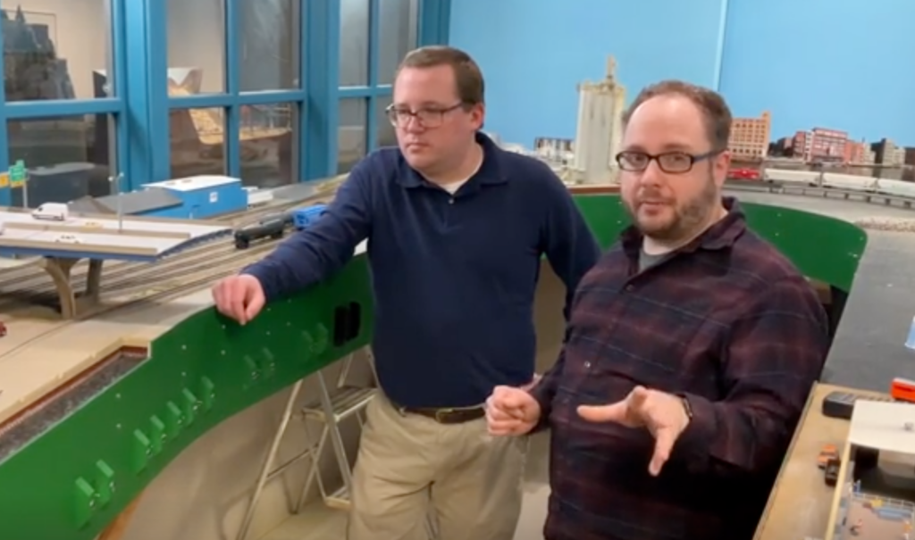 Midday Modeler 03.23.2022 — Two men in front of a model train layout.