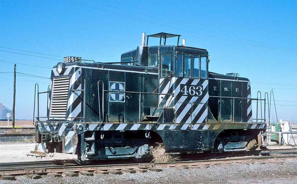 Black and white-stripped locomotive in a yard.