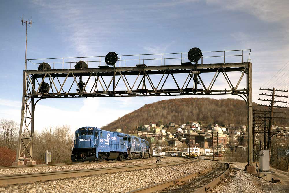 Conrail locomotives under signal bridge on curve