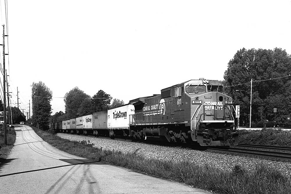 Diesel locomotive with trailers under signal bridge