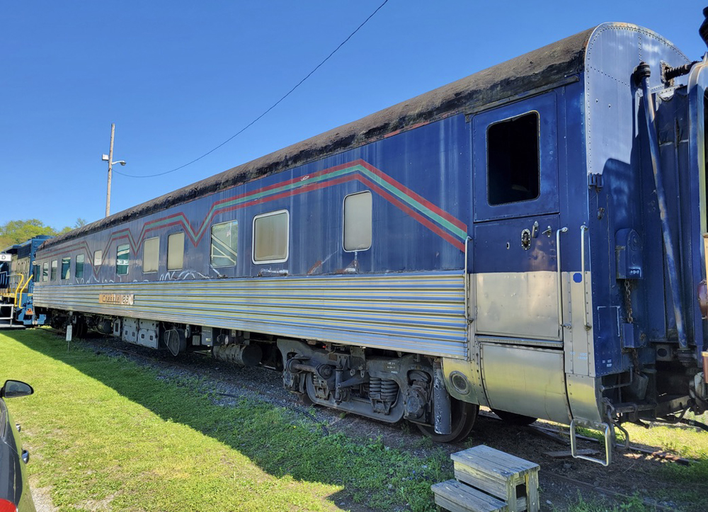 Passenger car with blue paint and multicolor striping over stainless steel lower body