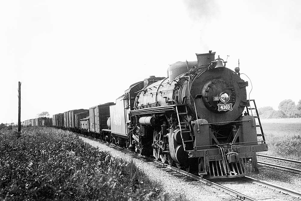 Steam locomotive leads a Frisco freight train on a curve