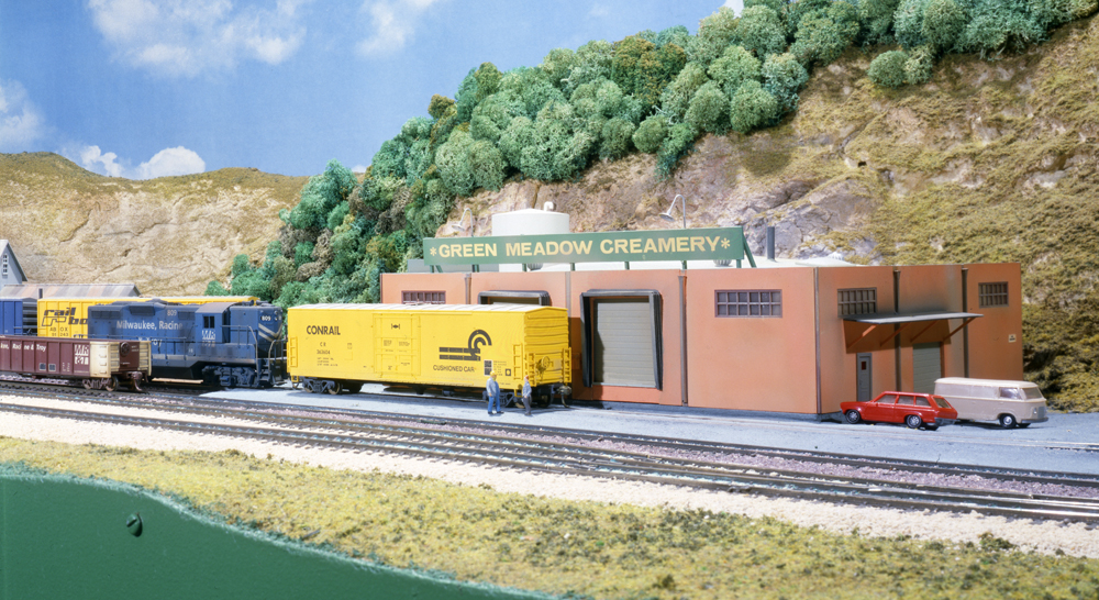 Photo of four-axle road unit switching cars on HO scale layout.