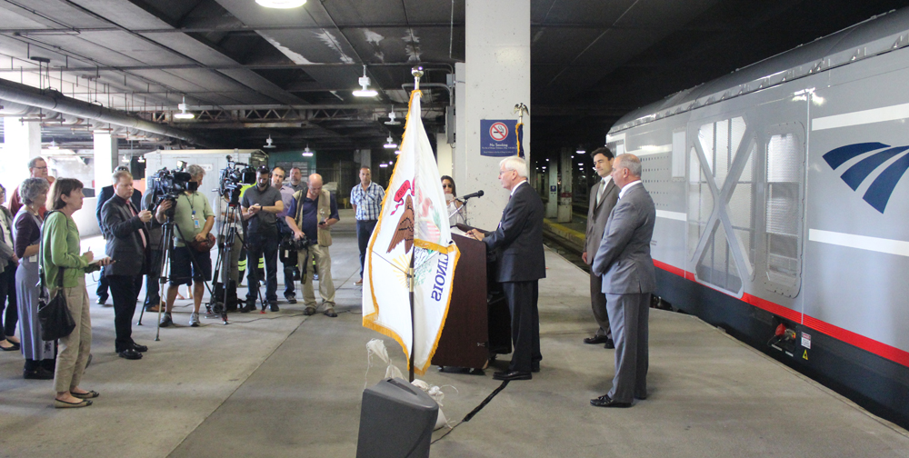 People gathered on station platform with locomotive as backdrop