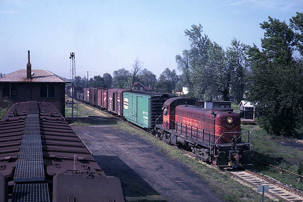 Maroon and red diesel locomotive with boxcars