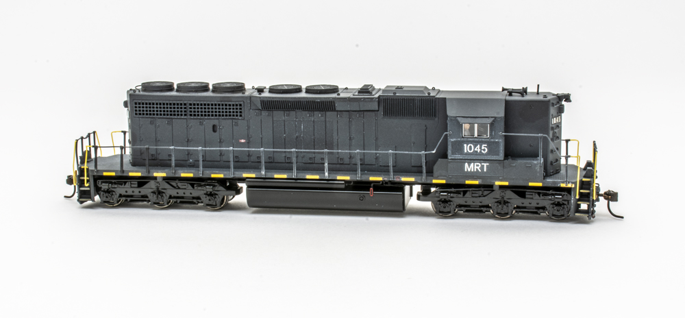 Photo of black high hood six-axle road locomotive on white background.