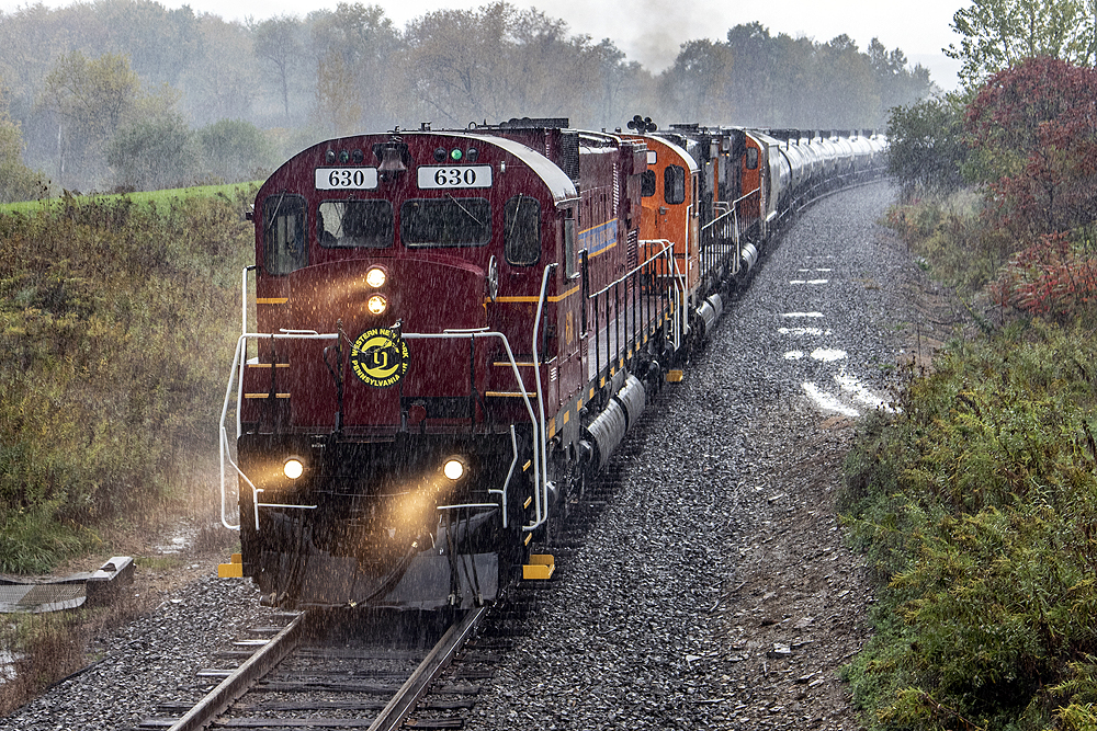 Locomotive leading a train in a downpour of rain.