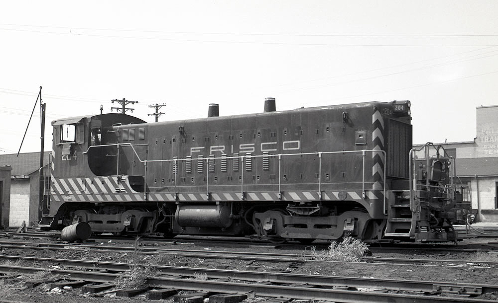 Black-and-white image of an end-cab switcher in a rail yard.
