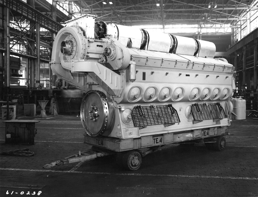 Top 3 diesel prime movers: Black and white image of a large diesel engine on a shop floor, on a heafty cart.