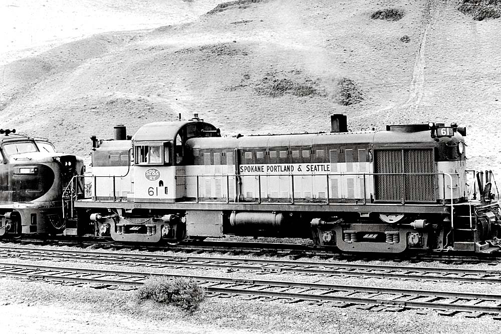 Four-axle diesel locomotive in front of hillside