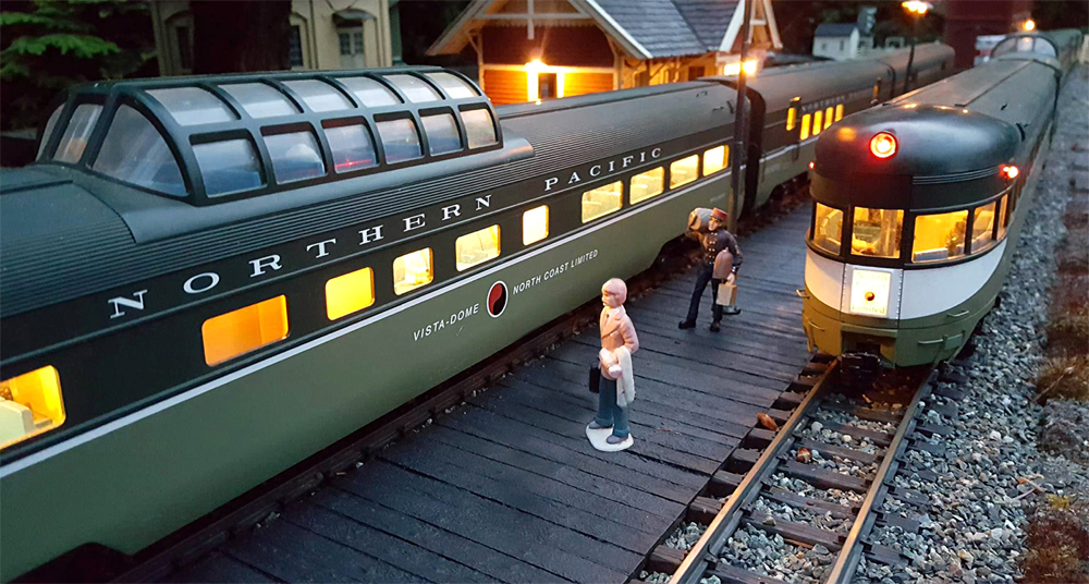 Model people on a platform with passenger train