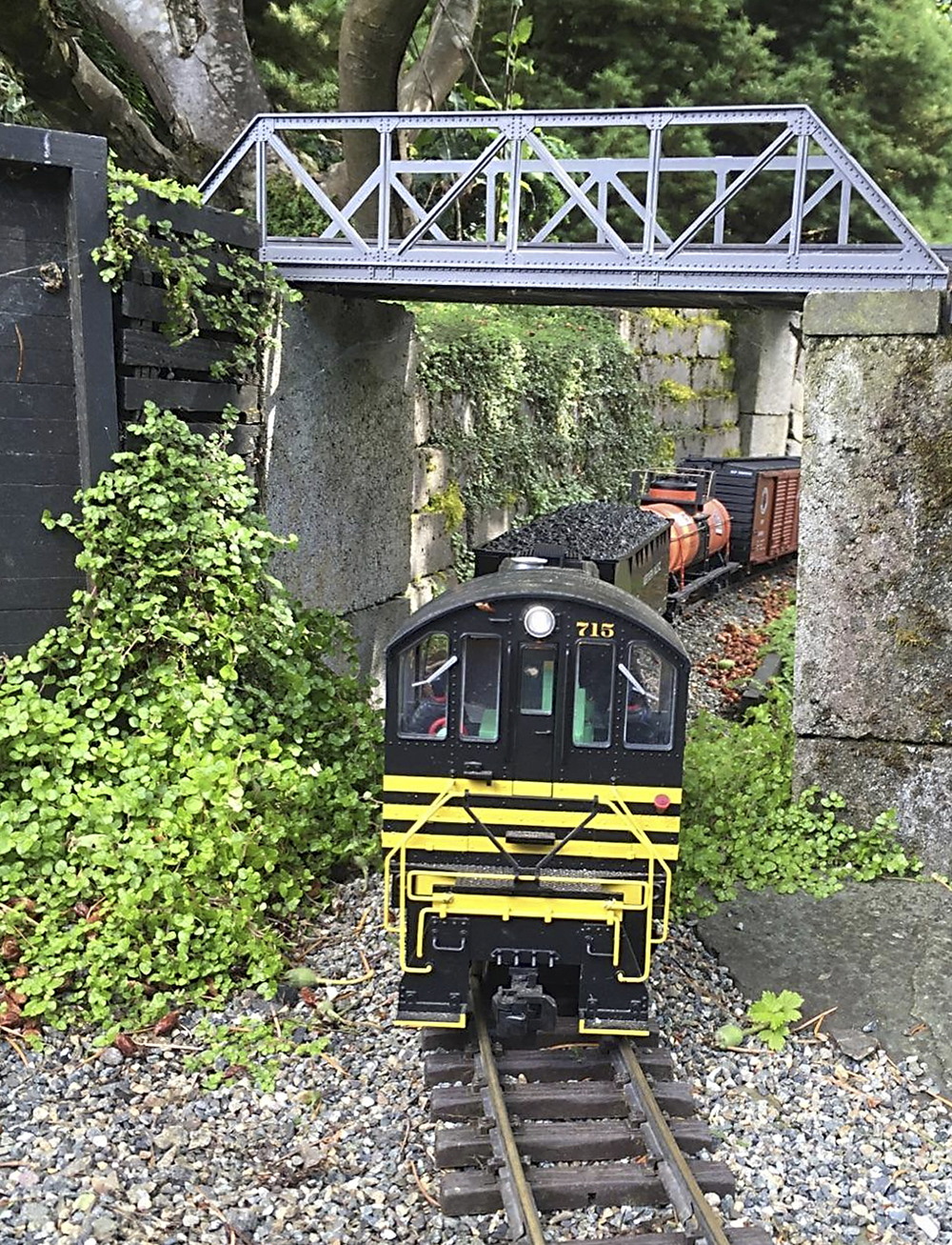 model locomotive travels under bridge