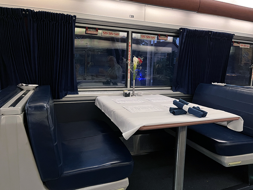 An empty table in a passenger train dining car.