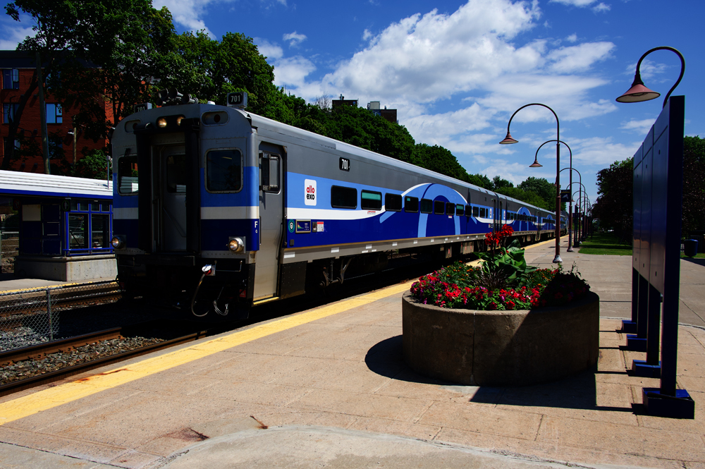 Cab car leads train of blue-and-silver commuter coaches at station