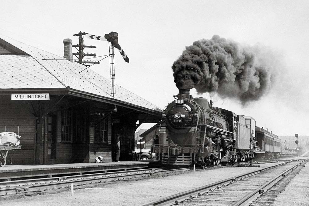 Steam Bangor Aroostook locomotive with train passing wooden station