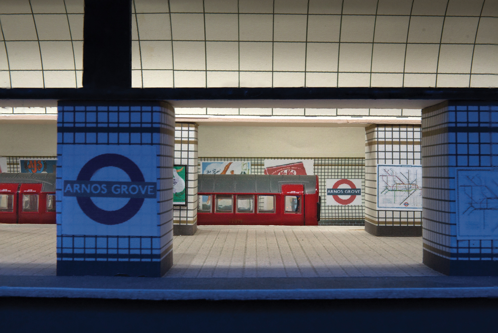 Red subway train in underground station.