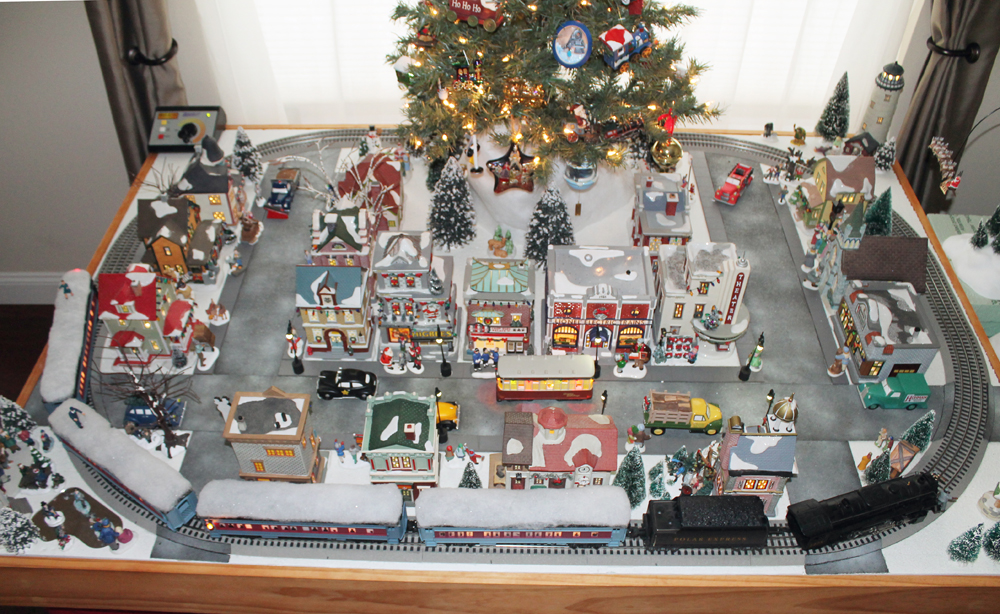 small Christmas tree with track and buildings around it
